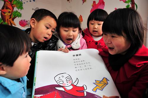 3月21日,湖北省宜昌市夷陵區(qū)機(jī)關(guān)幼兒園的老師在教小朋友唱兒歌。新華社發(fā)(張國(guó)榮 攝)