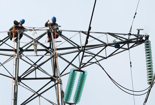 3月27日,江西九江供電公司的工人們?cè)诰沤?20千伏潯港輸電線路的鐵塔上帶電安裝“TH型組合避雷針”。新華社發(fā)(胡國林 攝)