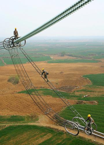 湖北超高壓輸變電公司的工人在特高壓輸電線上進(jìn)行線路巡查(4月15日攝)。新華社記者 郝同前 攝