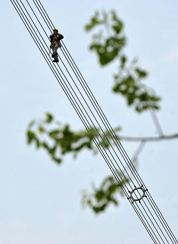 湖北超高壓輸變電公司的工人在特高壓輸電線上進(jìn)行線路巡查(4月15日攝)。新華社記者 郝同前 攝
