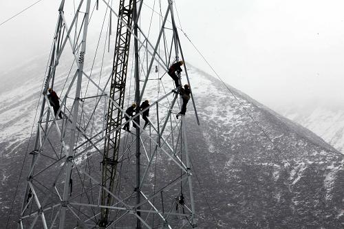 4月23日,在西藏念青唐古拉山脈海拔4700米處,貴州送變電公司員工在冒雪架設電力鐵塔。新華社發(fā)(牛路 攝)