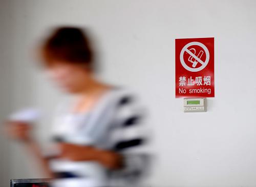 5月1日,在山西省太原客運西站,一名乘客從候車廳的禁煙提示牌前經(jīng)過。新華社記者燕雁攝