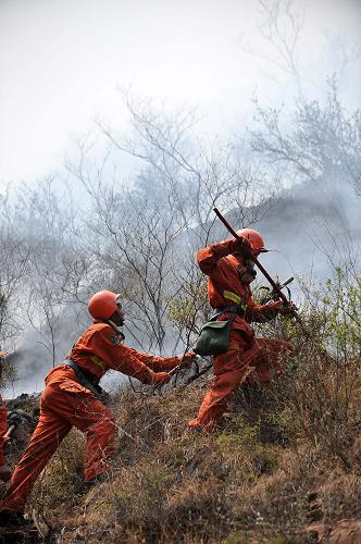 5月1日,在陽泉和晉中交界處森林火災(zāi)現(xiàn)場,中國武警森林指揮部機(jī)動支隊一大隊的隊員在控制火情。新華社記者 詹彥 攝