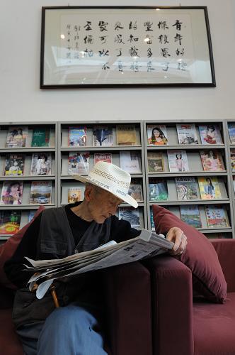 5月7日,一位老人在都江堰市圖書館一處書報借閱室讀報。新華社發(fā)(張帆 攝)