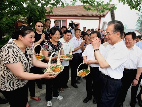 在汶川特大地震三周年和災(zāi)后恢復(fù)重建取得決定性勝利之際,5月7日至9日,中共中央政治局常委、國務(wù)院總理溫家寶第十次來到四川災(zāi)區(qū),親切看望慰問各族干部群眾,實(shí)地察看災(zāi)后恢復(fù)重建情況。這是5月8日,彭州市新興鎮(zhèn)壽陽泉村的村民請(qǐng)溫家寶總理品嘗櫻桃。新華社記者姚大偉攝