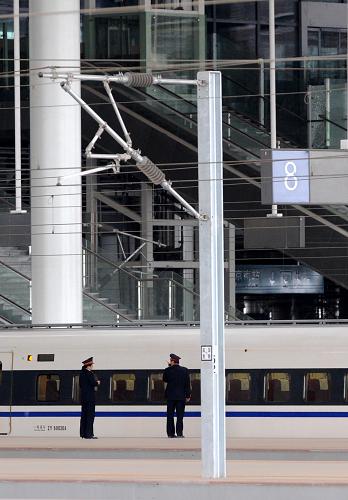 5月11日,一列試運行的動車組列車??烤哞F南京南站,鐵路人員在站臺上參與接發(fā)車工作。新華社記者孫參攝