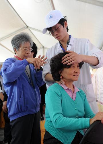 5月13日,一位市民(右)在體驗(yàn)中醫(yī)按摩。新華社記者 李文 攝