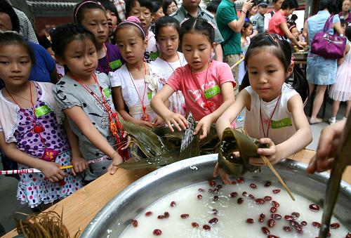 6月6日,在東岳廟北京民俗博物館舉行的民俗游園會上,小學(xué)生們饒有興致地參加包粽子比賽。新華社發(fā)(趙冰 攝)