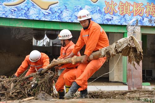 6月6日,消防官兵正在移除倒在望謨縣縣城路上的樹木。新華社發(fā)(覃苗苗 攝)