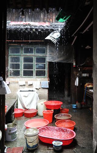 6月14日,杭州市上城區(qū)紫陽(yáng)街道木場(chǎng)巷社區(qū)的居民在接雨水。該街道是杭州老舊房屋較為集中的地區(qū)之一,地勢(shì)低洼,容易積水。街道已經(jīng)進(jìn)入防汛二級(jí)預(yù)案,社區(qū)工作人員24小時(shí)值班,準(zhǔn)備隨時(shí)應(yīng)對(duì)暴雨可能帶來的影響。新華社記者 徐昱 攝