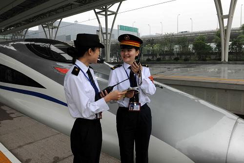 6月17日,CRH380高速動車剛剛??吭谏虾:鐦蚧疖囌?,車站值班員史潔敏(右)與列車工作人員進行站車交接工作。新華社記者 陳樹根 攝