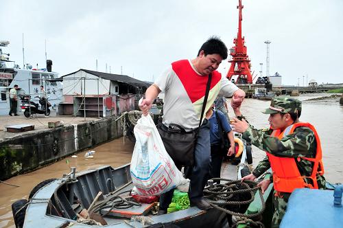 6月25日,在浙江省臺(tái)州市椒江海門港,邊防官兵幫助漁民轉(zhuǎn)移上岸。