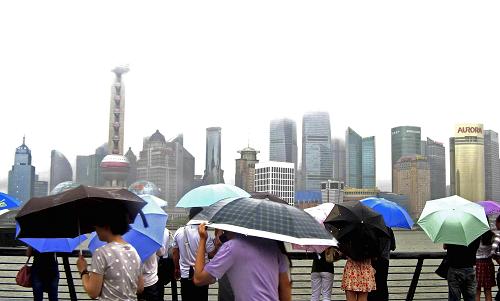 6月25日,游客冒著風(fēng)雨在上海外灘觀光。新華社發(fā)(嚴(yán)大明 攝)