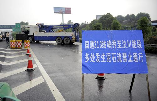 7月3日,交管部門在成都通往映秀的高速路口設(shè)立路卡。當日,連接成都與汶川的“生命線”213國道,因泥石流、山體垮塌再度中斷。連日來,四川連續(xù)遭受強降雨天氣,泥石流等災害頻發(fā)。記者7月3日16時許在213國道映秀至汶川段的一處塌方現(xiàn)場看到,泥石堆積物導致道路完全中斷,3臺重型機械車正在緊張進行搶通作業(yè)。新華社記者 李橋橋攝