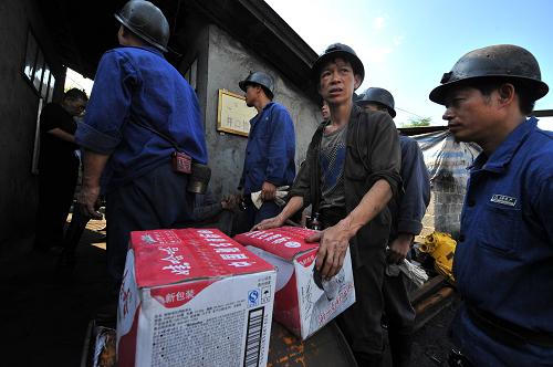 7月3日,救援人員準備帶著飲用水下井救援。當(dāng)日,記者在廣西來賓合山市合山煤業(yè)公司“7·2”事故處置指揮部了解到,已有井下淤泥被拉出井,救援速度開始加快,但目前現(xiàn)場開始下陣雨,為現(xiàn)場救援增加了新的難度;井內(nèi)作業(yè)面狹窄,挖掘這些淤積物非常困難;井下瓦斯?jié)舛绕?,雖不影響救援工作但須防止有害氣體溢出;井下的頂板不太穩(wěn)定,有發(fā)生次生災(zāi)害的可能,需有專人負責(zé)井下頂板安全。受多重困難影響,救援工作進展緩慢。 2日中午發(fā)生在廣西合山市合山煤業(yè)公司八礦樟村井的事故造成22人被困井下,其中3人已確認死亡,事故初步分析為強降雨導(dǎo)致地面塌陷引發(fā)井下事故。目前300多名現(xiàn)場救援人員在現(xiàn)場全力救援。 新華社記者 李斌 攝