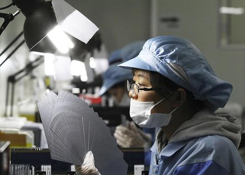 7月5日,山東濰坊一家臺(tái)灣獨(dú)資太陽能硅片制造企業(yè)員工在對多晶硅片進(jìn)行“目檢”。新華社發(fā)(孫樹寶 攝)