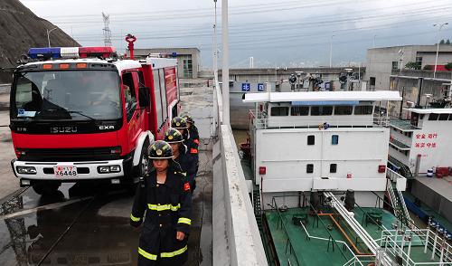 8月1日,武警三峽壩區(qū)消防特勤大隊出動消防車為過閘的危險品船舶護(hù)航。武警三峽壩區(qū)消防特勤大隊承擔(dān)著三峽壩區(qū)的防火監(jiān)督、滅火救援、反恐處突等重任,該大隊對通過三峽船閘的裝載易燃易爆等危險品的船只實行全程防火安全護(hù)送,保證船只和船閘的安全。從2004年底建隊至今,大隊官兵共為危險化學(xué)品護(hù)航1138次,確保5243艘危險品船舶安全通過五級船閘,確保了三峽大壩“零火災(zāi)”事故。新華社發(fā)(鄭家裕 攝)