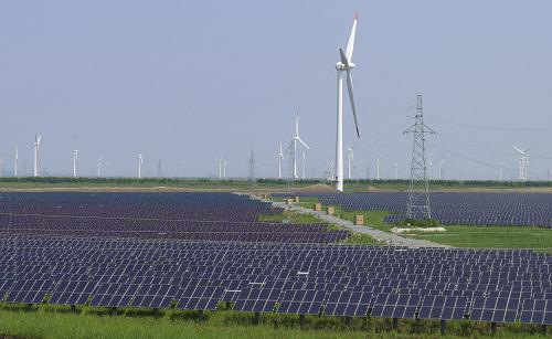 8月1日,在江蘇大豐市王港南側(cè)的黃海灘涂上,成片的光伏發(fā)電組件和聳立的風(fēng)電機組交相輝映。新華社發(fā)(周古凱 攝)