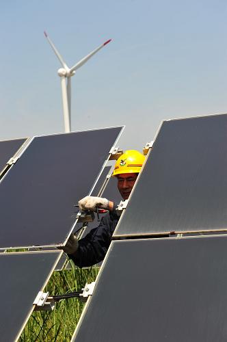 8月1日,在江蘇大豐的薄膜太陽能電站,工人悉心維護非晶硅薄膜光伏組件。新華社發(fā)(周古凱 攝)