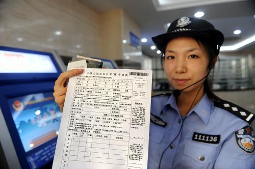 8月3日,一名女警在展示通過(guò)自助辦證機(jī)打印的出境申請(qǐng)表,不再需要手工填寫(xiě)。新華社記者李紫恒攝