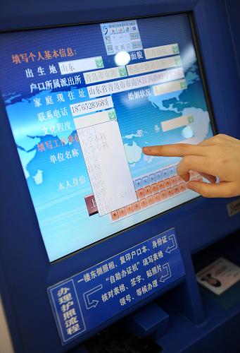 8月3日,一名工作人員在演示如何操作自助辦證機(jī)受理出境申請(qǐng)表。新華社記者李紫恒攝