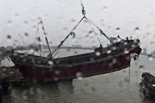 8月7日,在山東省海陽(yáng)市鳳城漁港,漁民冒雨將漁船吊運(yùn)至安全地方。新華社記者 郭緒雷 攝