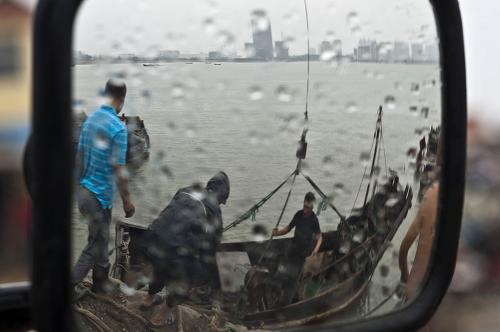 8月7日,在山東省海陽(yáng)市鳳城漁港,漁民冒雨用吊車(chē)將漁船吊起停放至安全地方。新華社記者 郭緒雷 攝