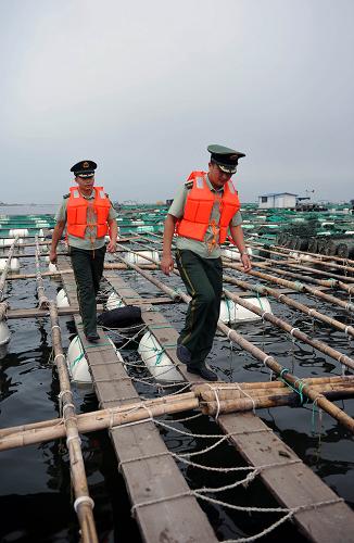 8月7日,煙臺(tái)邊防干警在魚(yú)排上巡邏檢查防風(fēng)措施。新華社發(fā)(臧保東 攝)