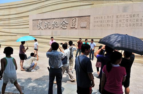 8月13日,游客在三峽大壩截流紀(jì)念園前拍照留念。新華社發(fā)(王輝富 攝)