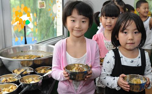 9月1日,陜西省榆林市東升幼兒園學(xué)前班的孩子們在教室里排隊就餐。新華社記者陶明攝