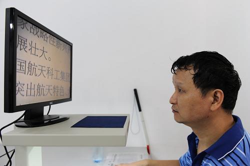 9月2日,邱興華在殘疾人閱覽室通過(guò)放大器來(lái)閱讀報(bào)紙。新華社記者 陳誠(chéng) 攝