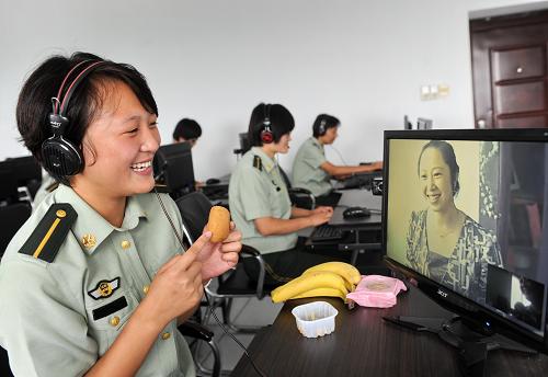 9月11日,來自黑龍江的入警大學生曹煌卓在警營網(wǎng)吧拿著月餅與母親分享中秋節(jié)日的快樂。當日,河北省公安邊防總隊教導大隊開展“中秋月餅送親人”活動。在這里集訓的來自全國各地的190多名入警大學生通過警營話吧、警營小網(wǎng)吧以打電話、視頻聊天的方式表達對親人的思念和中秋的祝福。新華社記者 楊世堯 攝