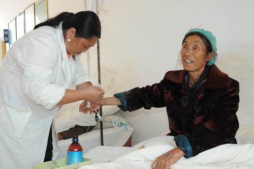 貴州省興義市下五屯納錄村衛(wèi)生室的村醫(yī)楊明花(左)在為村民輸液(9月21日攝)。長(zhǎng)期受交通條件和收入水平影響治病的山區(qū)農(nóng)民,是否也享受到了醫(yī)改帶來(lái)的便利和實(shí)惠?帶著這一疑問(wèn),記者近日走訪貴州省興義市下五屯街道辦事處的村衛(wèi)生室發(fā)現(xiàn),通過(guò)實(shí)施鄉(xiāng)村一體化管理,新農(nóng)合和基本藥物讓山區(qū)農(nóng)民看病難得到緩解。新華社記者 李勁峰 攝