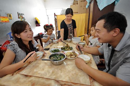 9月29日,外來工周曉君(右一)一家在廉租住房里用餐。2010年初,來自四川省大竹縣川主鄉(xiāng)的周曉君一家五口住進(jìn)了晉江市深滬鎮(zhèn)外來職工廉租住房小區(qū),從此告別了高價(jià)租住的生活。 近年來,福建省晉江市加快外來職工廉租住房的建設(shè)步伐。從2009年起,晉江市在務(wù)工人員相對密集的深滬鎮(zhèn)、晉江經(jīng)濟(jì)開發(fā)區(qū)五里園、陳埭鎮(zhèn)、新塘街道等地,啟動(dòng)了5個(gè)外來職工廉租住房項(xiàng)目,在建總建筑面積26.34萬平方米,總投資5.5億元,可提供廉租住房4575套。截至目前,這5個(gè)項(xiàng)目的廉租房中有1400多套已封頂,200多套交付使用,其余的將在兩年內(nèi)陸續(xù)交付使用。晉江市是福建省民營經(jīng)濟(jì)發(fā)達(dá)地區(qū),目前在這里的外來務(wù)工人員已超過100萬人。新華社記者 張國俊 攝