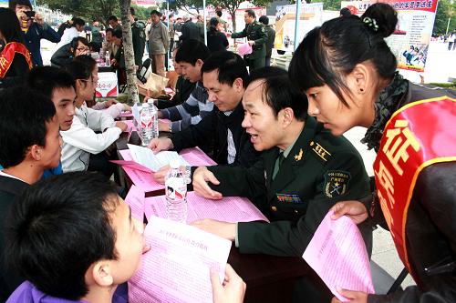 10月29日,在廣西賀州市街頭,工作人員向適齡青年介紹今冬征兵政策。新華社發(fā)(黃旭胡 攝)