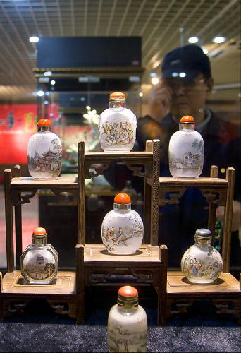 11月5日,觀眾在第四屆非物質(zhì)文化遺產(chǎn)手工藝品交易博覽會(huì)上觀看內(nèi)畫鼻煙壺。新華社發(fā)(趙冰 攝)