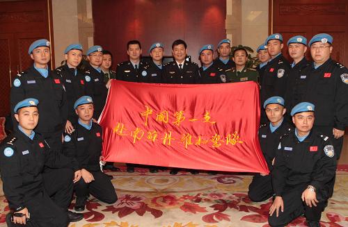 11月11日,維和警隊(duì)隊(duì)員在北京首都國(guó)際機(jī)場(chǎng)與隊(duì)旗合影。新華社記者 袁滿 攝