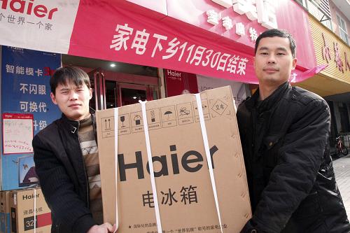11月30日,河南省寶豐縣農(nóng)民將選購的“家電下鄉(xiāng)”冰箱搬回家。新華社發(fā)(王雙正 攝)