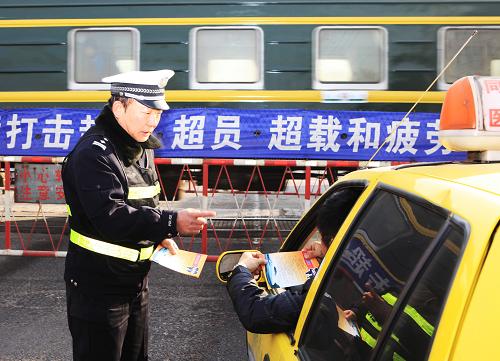 12月23日,錦州鐵路公安處交警支隊(duì)民警正在向過往鐵路平交道口的司機(jī)、行人散發(fā)安全通過道口宣傳單。春運(yùn)來臨之前,錦州鐵路公安處組織民警深入管內(nèi)各平交道口,進(jìn)行安全宣傳。新華社發(fā)(高錦旭攝)