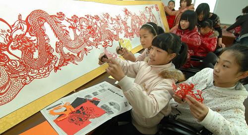 12月26日,遼寧省錦州市太和小學(xué)學(xué)生在創(chuàng)作有關(guān)龍的剪紙。當(dāng)日,遼寧省錦州市民俗剪紙?zhí)厣珜W(xué)校太和小學(xué)六年級百名屬龍的少年,在校園內(nèi)創(chuàng)作有關(guān)龍的剪紙,迎接農(nóng)歷龍年的到來。新華社發(fā)(李鐵成 攝)