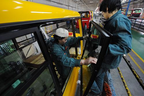 12月26日,恒通客車總裝車間的工人在為校車安裝車窗。重慶恒通客車有限公司成立于1939年,從2004年開(kāi)始著手安全校車的研制,現(xiàn)已推出了多款加強(qiáng)型安全校車。其中,一款與歐美校車外形相似的“長(zhǎng)鼻子”校車,受到專家和社會(huì)一致好評(píng)。該車配有防碰撞報(bào)警系統(tǒng)、GPS及后胎視頻監(jiān)控系統(tǒng)、防爆油箱、遙控式破車窗玻璃應(yīng)急逃生裝置、防扎防漏輪胎等十大安全系統(tǒng)。新華社記者 李健 攝