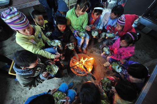 1月6日,在廣西馬山縣白山鎮(zhèn)民新小學(xué),學(xué)生們一邊烤火,一邊享用免費(fèi)午餐。 隆冬時(shí)節(jié),位于廣西大山之中的馬山縣白山鎮(zhèn)民新小學(xué)70多名小學(xué)生每天都能享受熱騰騰的免費(fèi)營(yíng)養(yǎng)午餐。記者從廣西壯族自治區(qū)政府獲悉,廣西已經(jīng)在國(guó)家確定的農(nóng)村義務(wù)教育學(xué)生“營(yíng)養(yǎng)午餐”29個(gè)試點(diǎn)縣的基礎(chǔ)上,新增11個(gè)區(qū)級(jí)試點(diǎn)縣,這意味著廣西已經(jīng)有40個(gè)縣區(qū)、116萬(wàn)農(nóng)村中小學(xué)生能夠享受到“營(yíng)養(yǎng)午餐”。新華社記者 黃孝邦 攝