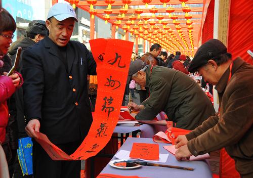1月16日,市民在遼寧大連市“龍年文化街”上自己動(dòng)手寫楹聯(lián)。新華社發(fā)(呂文正 攝)