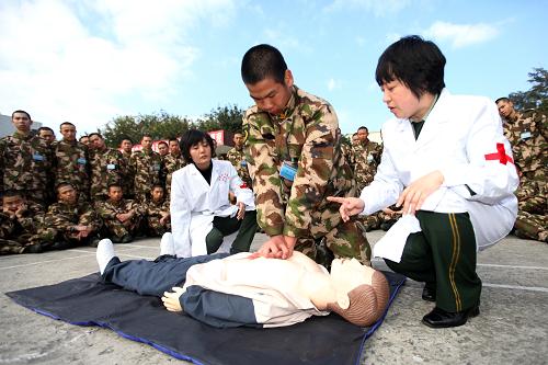 1月17日,深圳特檢站后勤處衛(wèi)生隊隊長張春玉(右一)在指導新兵張小龍(中)做心肺復蘇。新華社發(fā)(林鑫 攝)