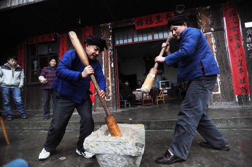 1月17日,翟再來(左)和鄰居一起打糍粑。新華社記者 李尕 攝
