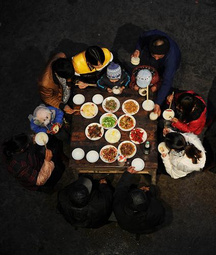 1月17日,翟再來(右上)將糍粑放上小年夜飯餐桌。新華社記者 李尕 攝
