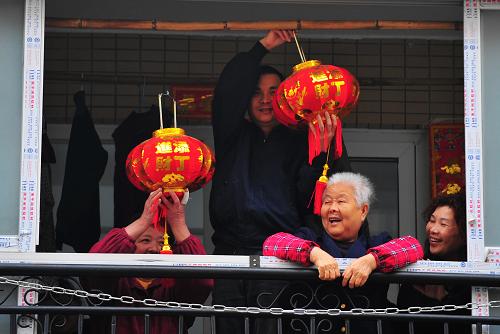 1月19日,剛搬入新居的低保戶馬建平(左二)在鄰里鄉(xiāng)親幫助下,為新家陽臺掛上紅燈籠,慶祝喜遷福州東山新苑三區(qū)廉租新房。當(dāng)日,福州市晉安區(qū)、鼓山鎮(zhèn)紀(jì)檢監(jiān)察人員和社會保障房社區(qū)工作人員來到轄區(qū)保障房項(xiàng)目樓盤福州東山新苑,幫助低保戶家庭搬新家、貼對聯(lián),并送上慰問金和愛心大禮包,讓困難戶在新家內(nèi)歡歡喜喜地過上一個愉快、舒心的新年。 2011年,福州市新建保障性安居工程58430套(戶)。其中,廉租房829套、發(fā)放公共租賃補(bǔ)貼1200戶。同時,福州市還將監(jiān)督檢查貫穿于保障性住房的建設(shè)、分配、監(jiān)管全過程,促進(jìn)保障性安居工程建設(shè)政策落實(shí),讓更多低收入家庭實(shí)現(xiàn)住有所居的夢想。新華社記者魏培全攝