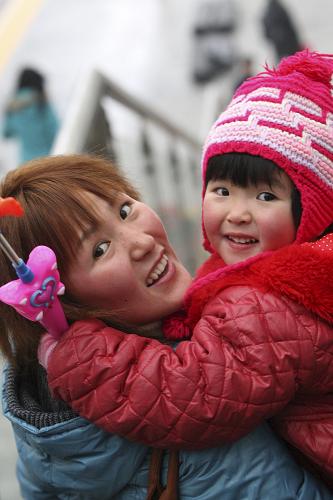 1月19日,在煙臺火車站,一對母子乘電梯走下月臺。 當(dāng)日,2012年全國鐵路運輸進入春節(jié)前客流高峰。山東煙臺火車站預(yù)計運送旅客1.6萬余人,比春運第一天增加4000余人。 新華社發(fā)(申吉忠 攝)