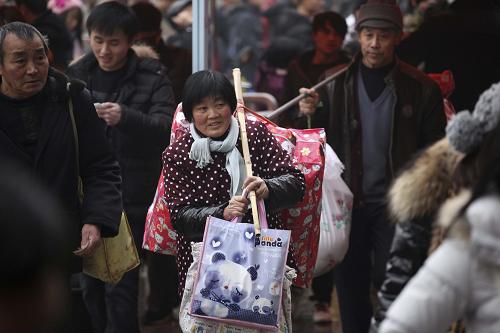 1月19日,旅客們扛著行李走進南京中央門長途汽車站。當(dāng)日,南京中央門長途汽車站客流猛增。新華社發(fā)(李文寶 攝)