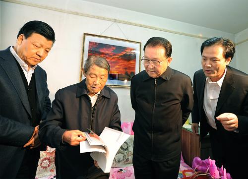 這是1月19日,李長(zhǎng)春在看望攝影藝術(shù)家袁毅平時(shí),一起觀看攝影作品。新華社記者劉建生攝